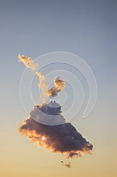 Paragliding at dusk with strikingly lit cloud