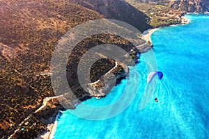 Paragliding flight over the sea coast of the Mediterranean Sea. Blue parachute against the blue sea. Turkey. Oludeniz. Aerial phot