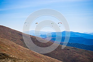 Paragliding group in air sport on top of a mountain. The whole world is in sight.