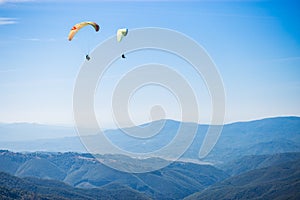Paragliding group in air sport on top of a mountain. The whole world is in sight.