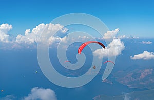 Paragliding in mountains near clouds