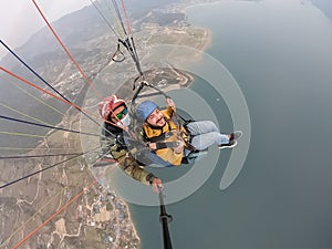 Paragliding in the mountains, the two persons on the top of the mountain, the parachutists are flying with a parachute