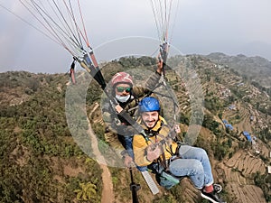 Paragliding in the mountains, the two persons on the top of the mountain, the parachutists are flying with a parachute