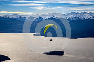 Paragliding over Nahuel Huapi lake and mountains of Bariloche in Argentina, with snowed peaks in the background. Concept of