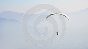 Paragliding silhouette and misty mountain