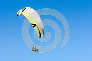 Paragliding sport flight on soaring wing in clear blue sky