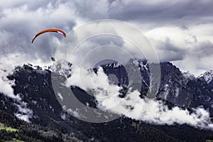 Paragliding in the Stubai Alps under cloudy skies