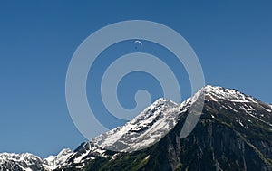 Paragliding in the Swiss Alps above snow covered peaks