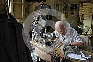 Paraguayan Senior tailor is sewing in dressmaking