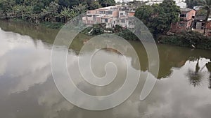 Paraiba do Sul river in Volta Redonda, Rio de Janeiro. houses on the banks of the polluted river