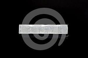 Parallel chocolate bars in silver packaging on black background