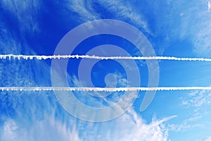 Parallel plane contrails in blue sky photo