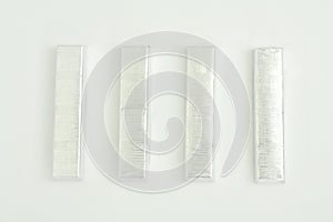 Paralleled chocolate bars in silver packaging on background