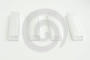 Paralleled chocolate bars in silver packaging on background