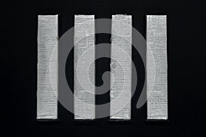 Paralleled chocolate bars in silver packaging on background