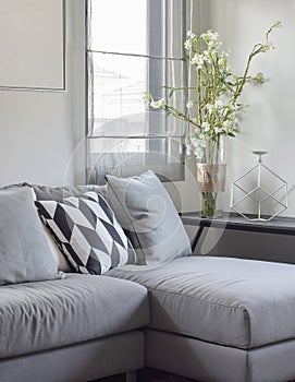 Parallelogram pattern pillow and gray pillows setting on gray sofa