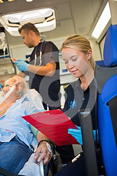 Paramedic assisting injured patient in ambulance