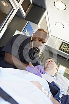 Paramedic attending to patient in ambulance