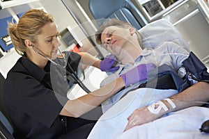 Paramedic attending to patient in ambulance photo