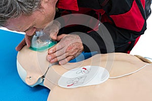 Paramedic blowing oxygen to dummy