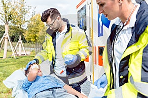 Paramedic and emergency doctor caring for injured boy