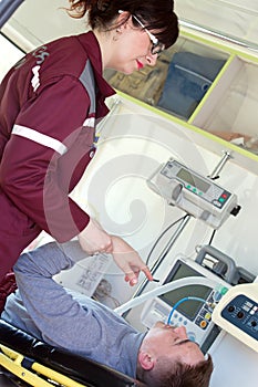 Paramedic female checking pulse unconscious patient