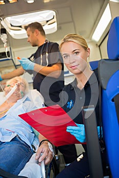 Paramedic helping injured patient in ambulance