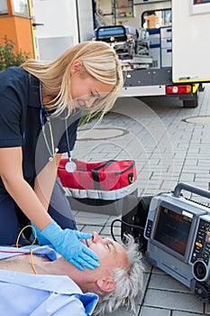 Paramedic helping injured patient on street