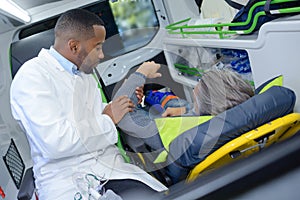 Paramedic holding arm man in ambulance