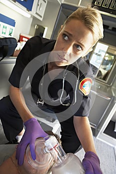 Paramedic holding oxygen mask over patient's face