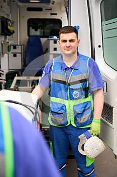 Paramedic holds a neck brace in his hands