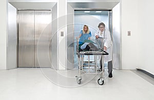 Paramedic and nurse pushing the patient bed out of the elevator to the emergency room of the hospital