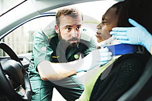 Paramedic placing a cervical collar to an injured woman from car accident photo