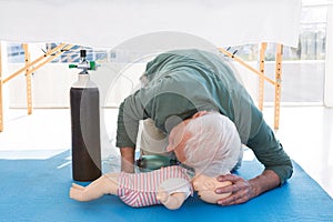 Paramedic practicing resuscitation on dummy