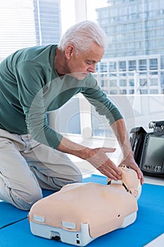 Paramedic practicing resuscitation on dummy