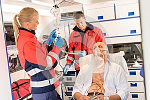 Paramedic putting oxygen mask on patient ambulance