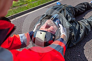 Paramedic removes an helmet from an injured biker