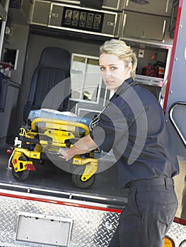 Paramedic removing gurney from ambulance