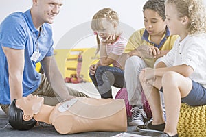 Paramedic showing defibrillator on manikin