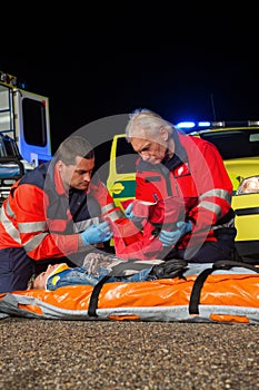 Paramedic team giving firstaid to injured woman