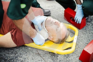 Paramedic team placing a cervical collar to an injured man