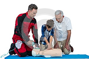 Paramedic training cardiopulmonary resuscitation to senior man and boy