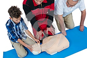 Paramedic training cardiopulmonary resuscitation to senior man and boy