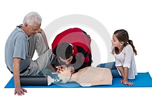 Paramedic training cardiopulmonary resuscitation to senior man and girl