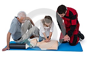 Paramedic training cardiopulmonary resuscitation to senior man and girl