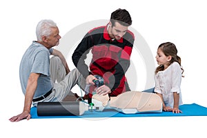 Paramedic training cardiopulmonary resuscitation to senior man and girl