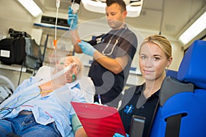 Paramedic treating unconscious man in ambulance