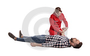 Paramedic in uniform performing first aid on unconscious man against white background