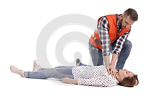 Paramedic in uniform performing first aid on unconscious woman against white background