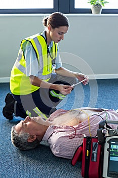 Paramedic using an external defibrillator during cardiopulmonary resuscitation